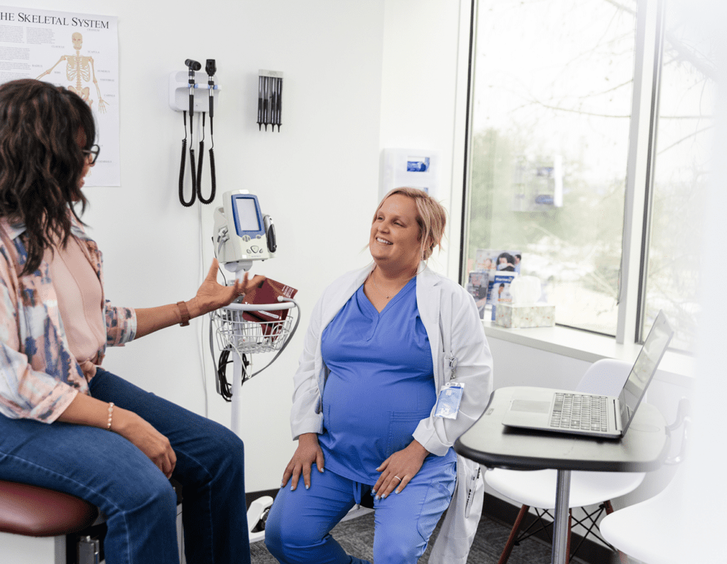 Doctor consulting with a pregnant woman in a medical office.