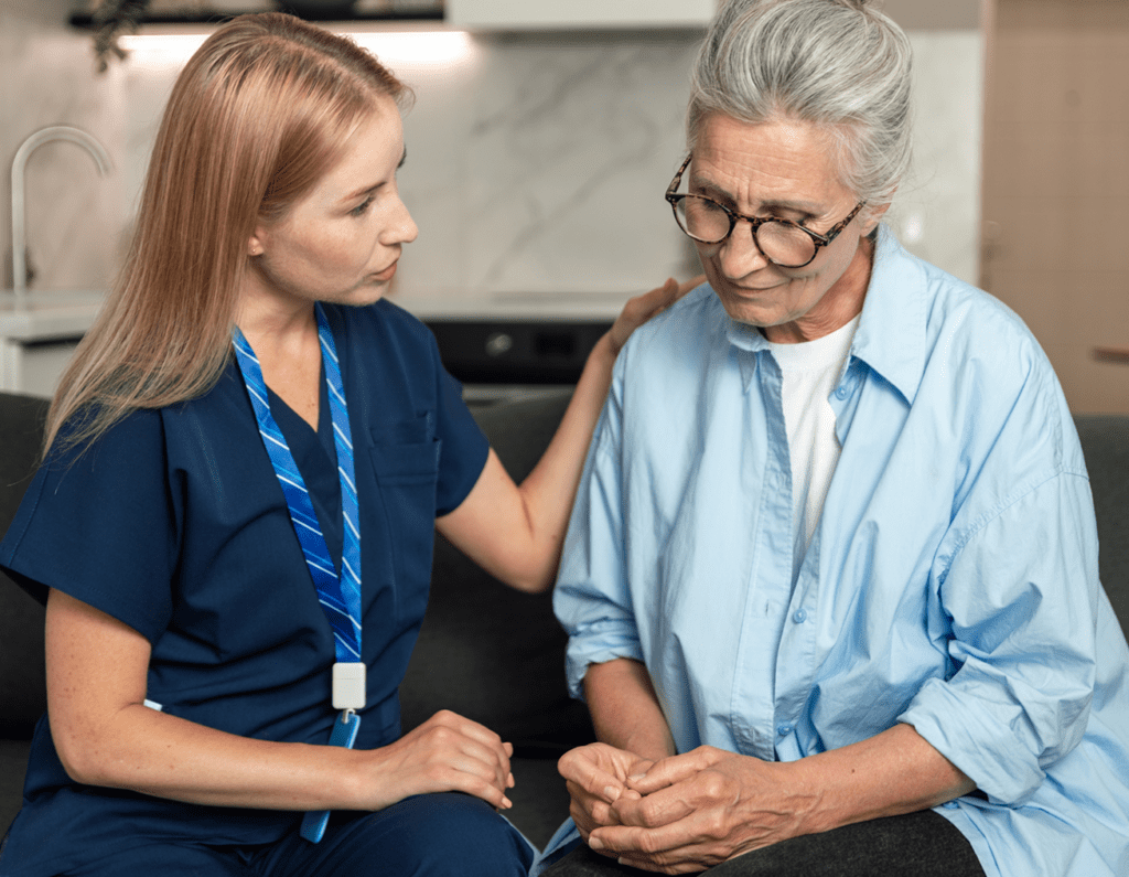 A nurse comforting an elderly woman with a gentle touch.