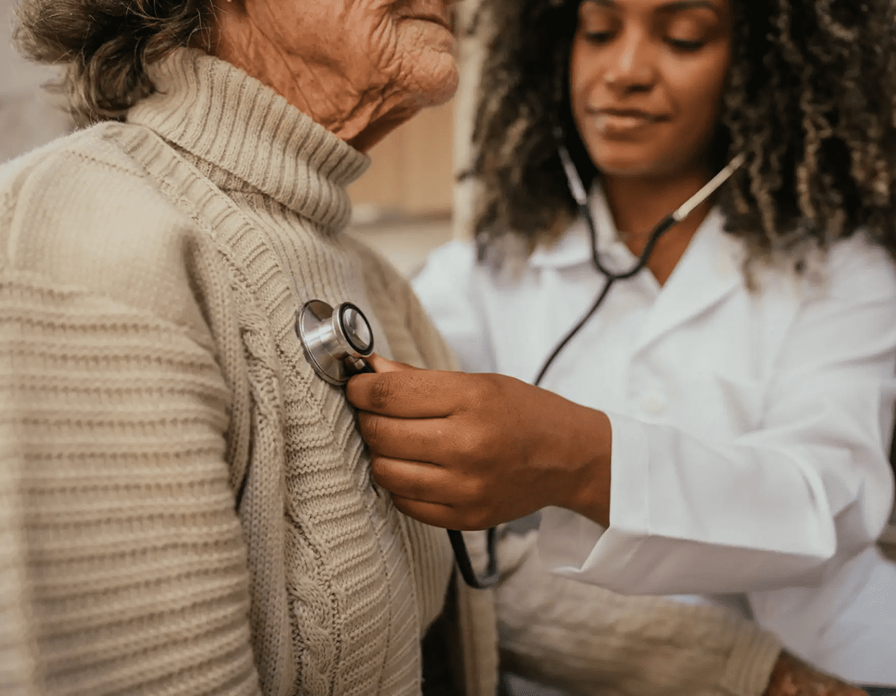 Doctor using stethoscope to check elderly patient's heartbeat.
