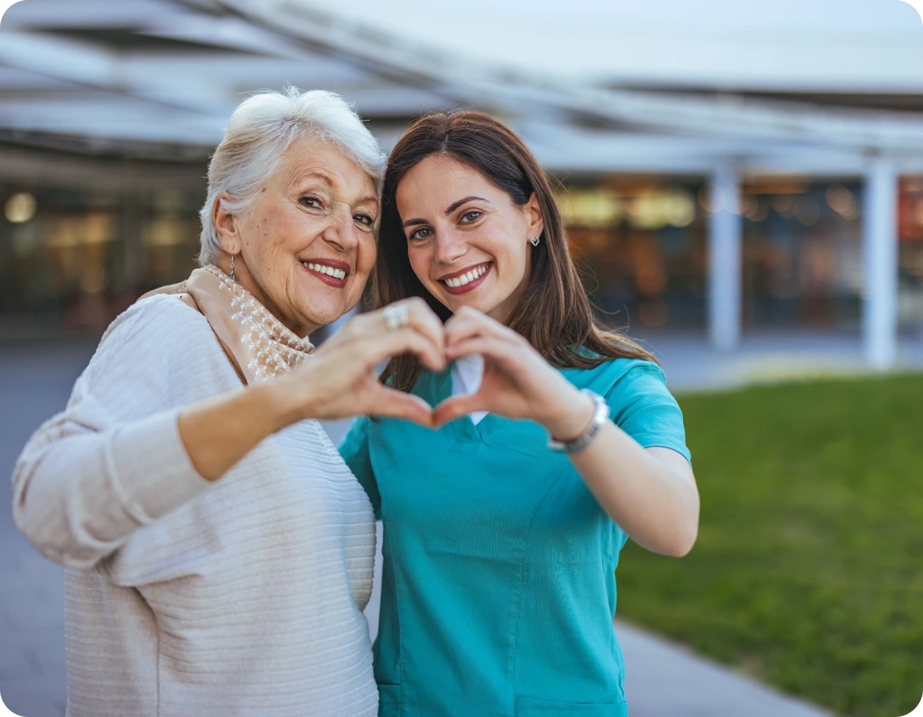 Elderly woman and young woman making heart.